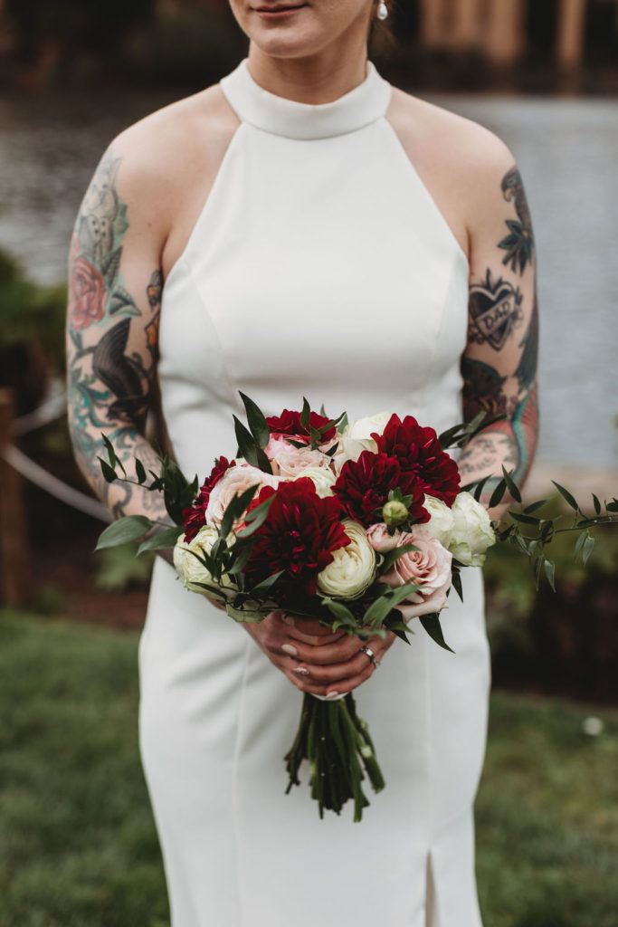 tattooed bride holding fall wedding flowers