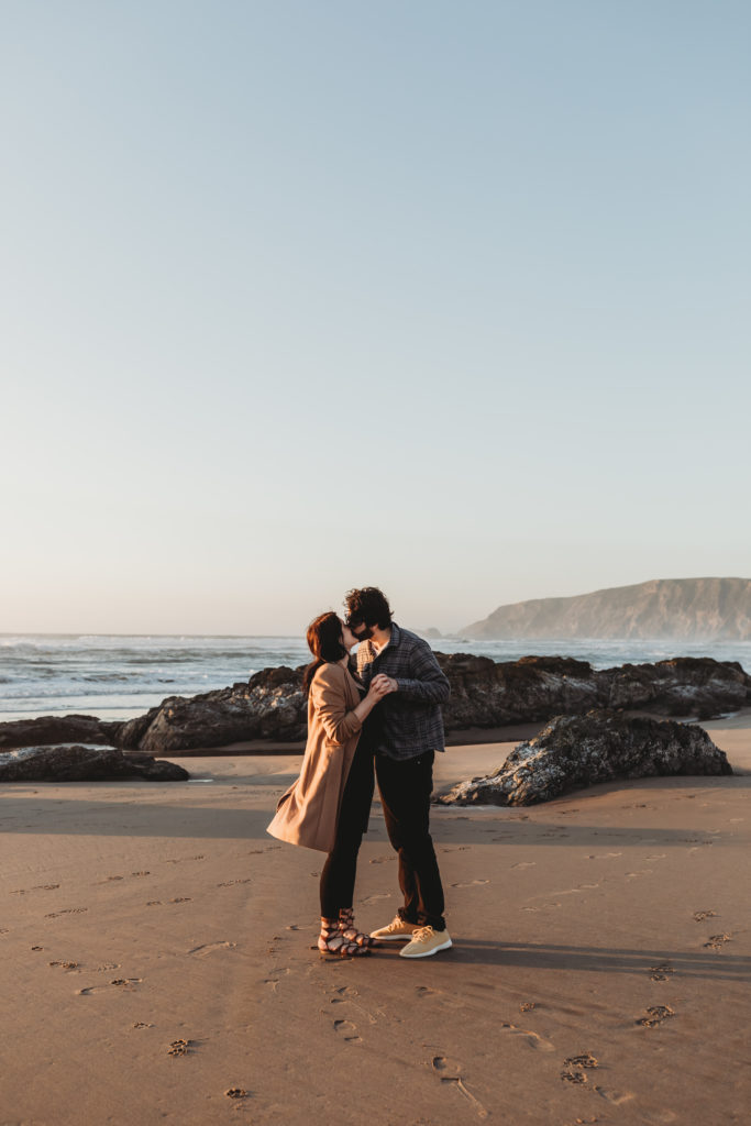 couple standing on beach at point reyes during engagement session