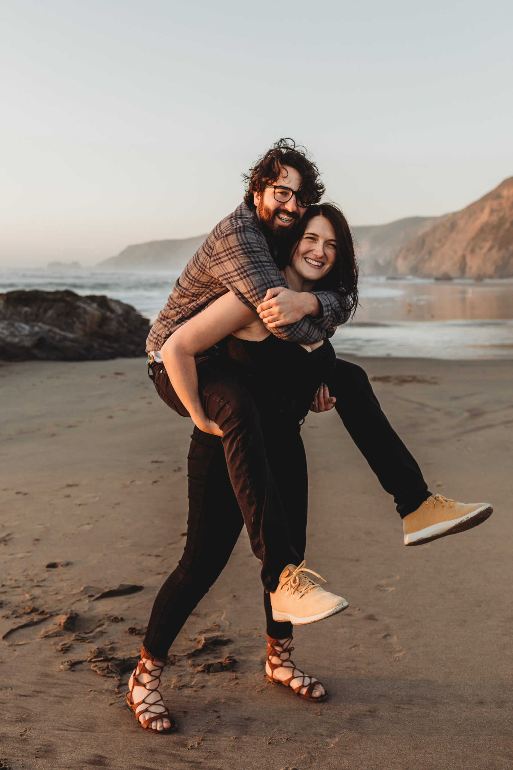 couple being playful at beach during engagement session