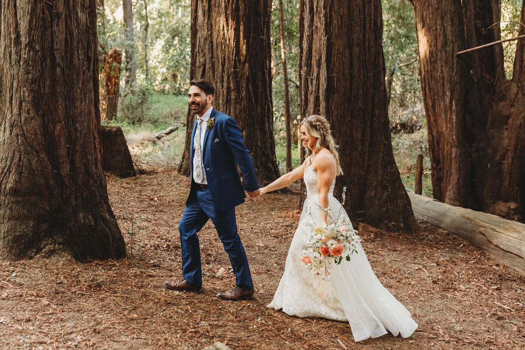 couple holding hands at forest wedding