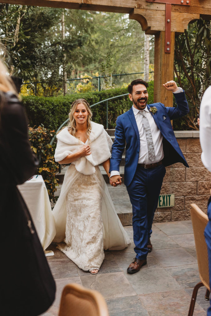bride and groom walking into wedding reception 