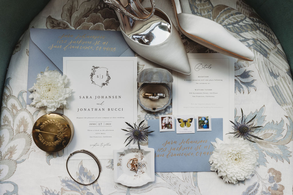 Wedding details with invites, wedding rings, shoes and flowers