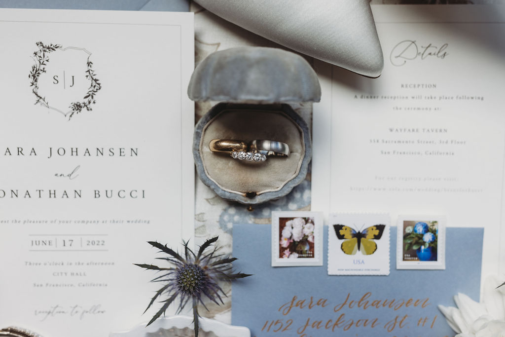 Wedding details with invites and wedding rings 