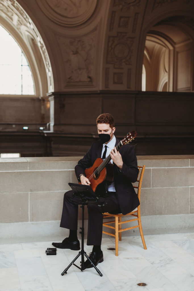 Man playing guitar for city hall wedding