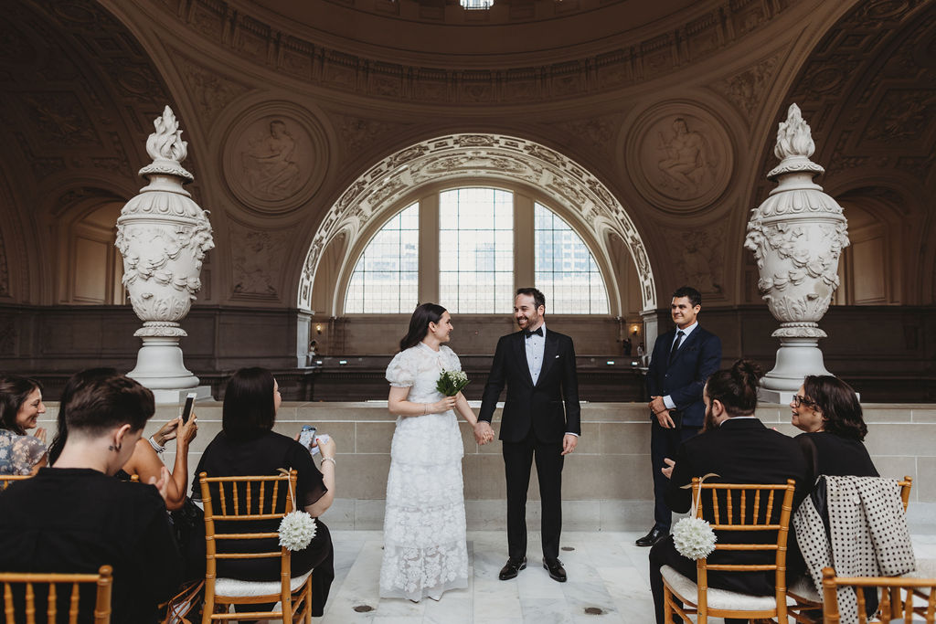 bride and groom walking down the aisle after san francisco city hall wedding