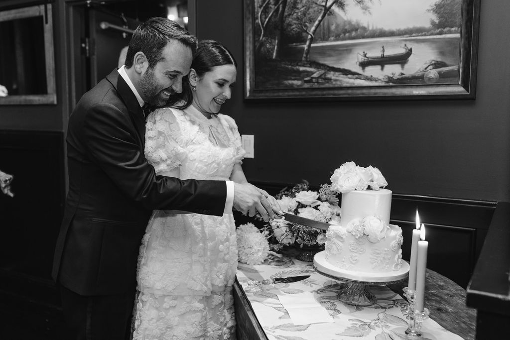 bride and groom cutting into wedding cake during reception 