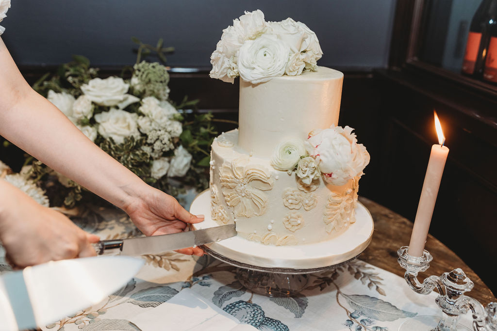 bride and groom cutting into wedding cake
