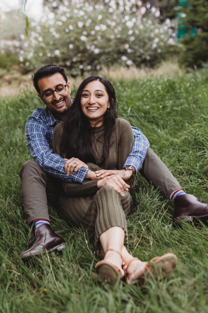 couple sitting in the grass for engagement photos