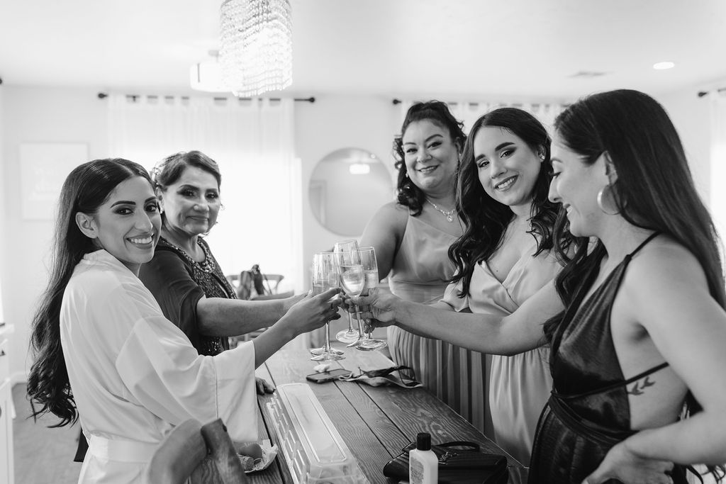 Bride and bridesmaids getting ready and toasting before wedding ceremony