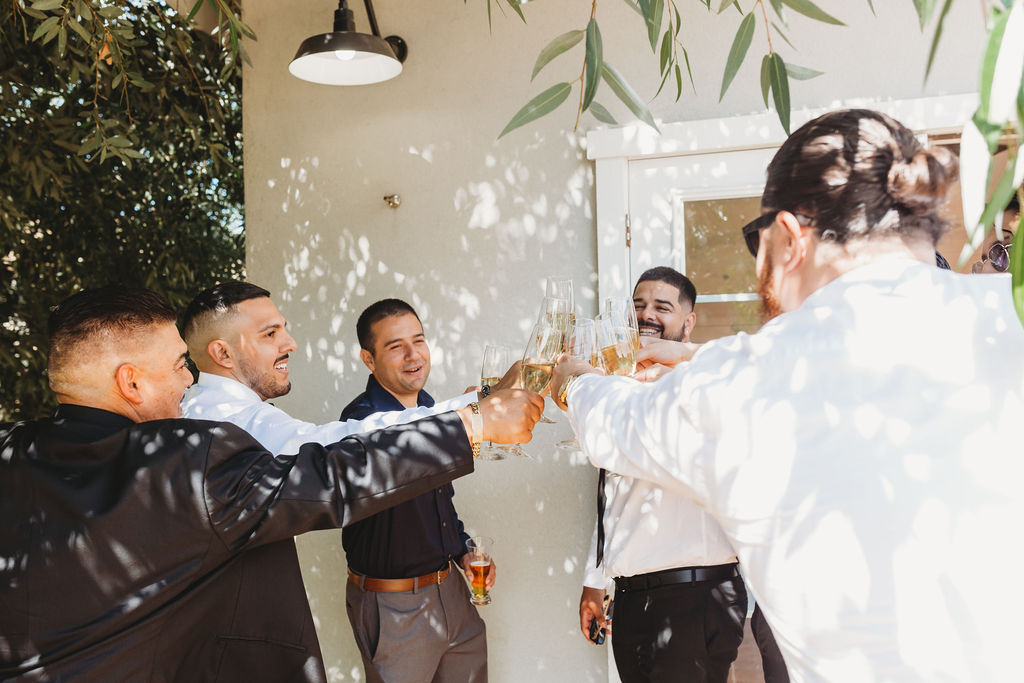 Groom and groomsmen toasting before wedding ceremony