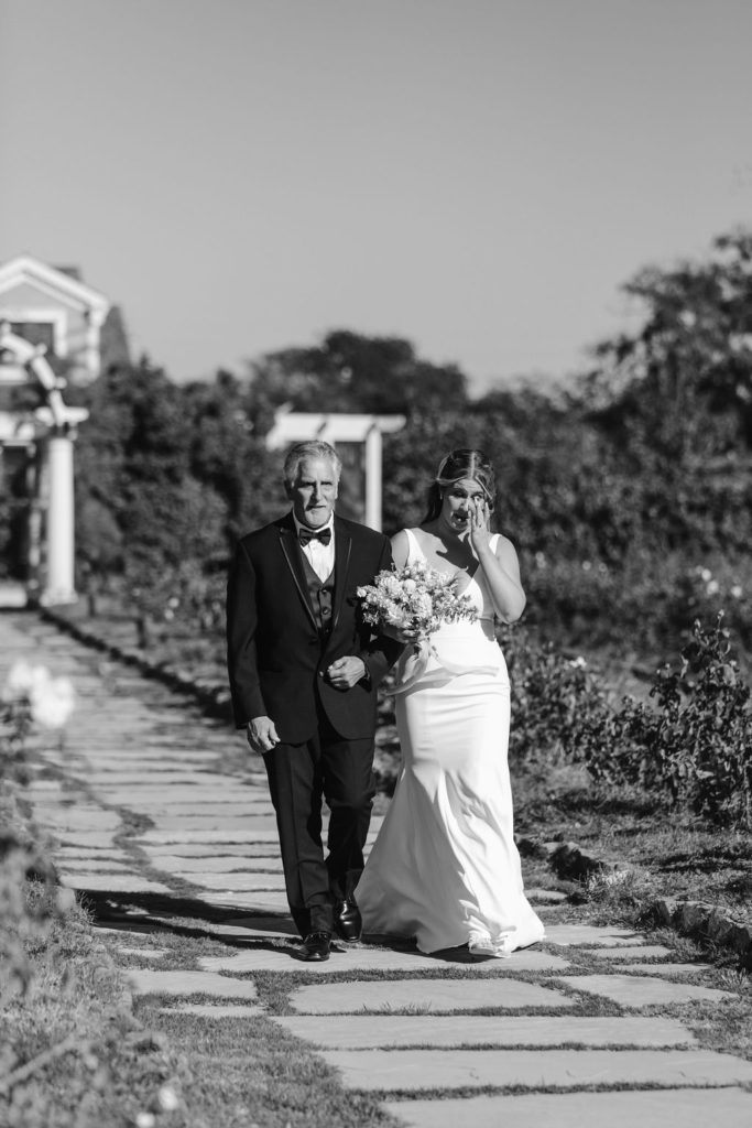 emotional bride walking down the aisle with father