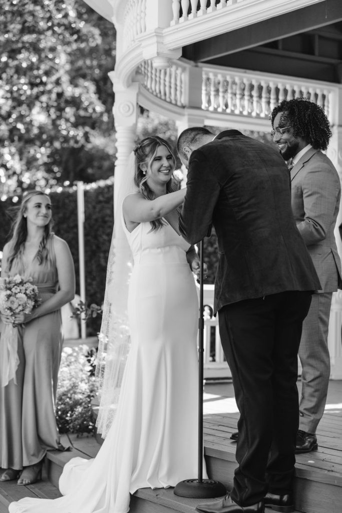 groom kissing brides hand at the altar