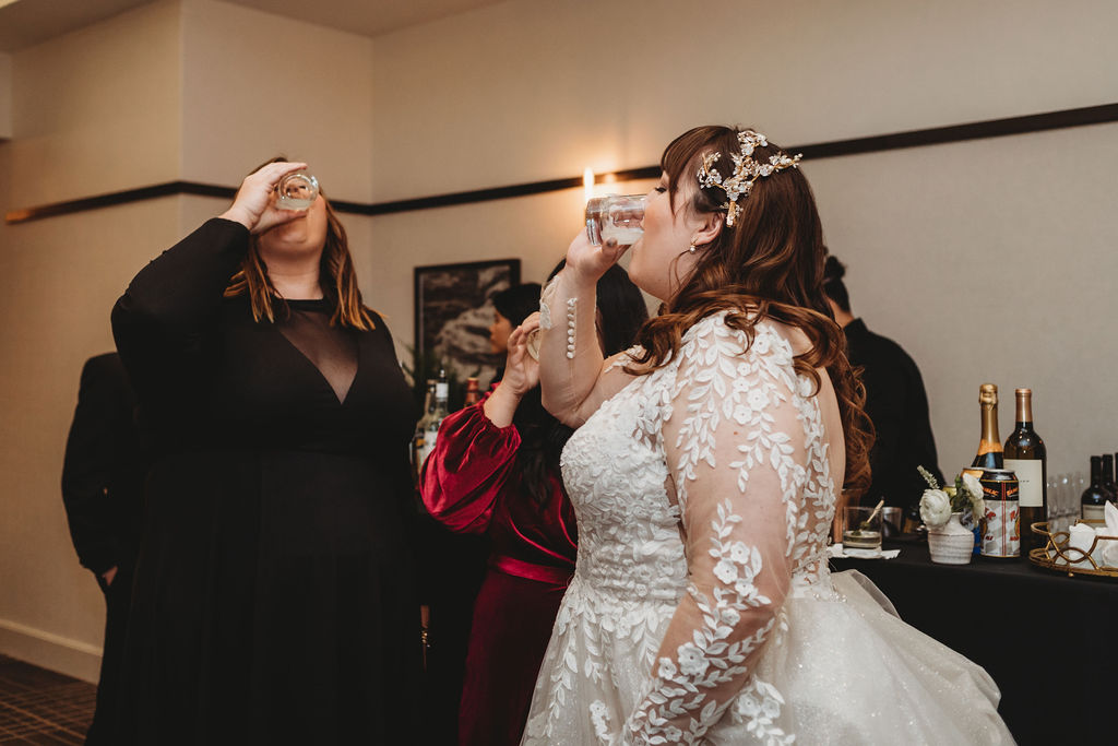 Bride taking shots with wedding guests