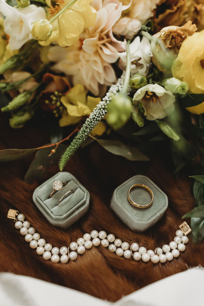 Wedding details with rings and pearl necklace