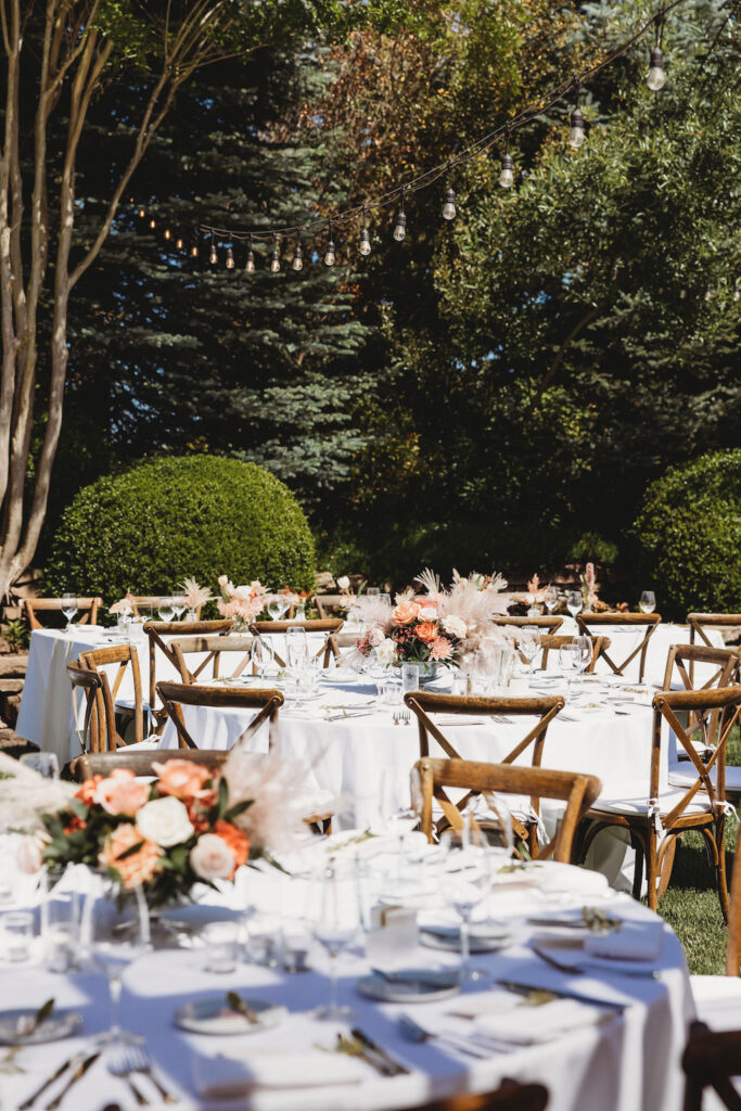 farm style outdoor reception with white table cloth with floral centerpieces