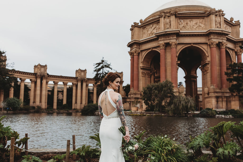 bride in front of Palace of Fine Arts lake with backless wedding dress