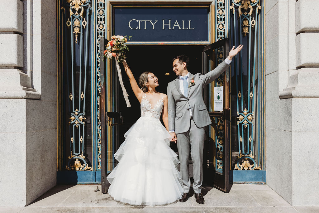 Newlywed couple standing in front of San Francisco City Hall